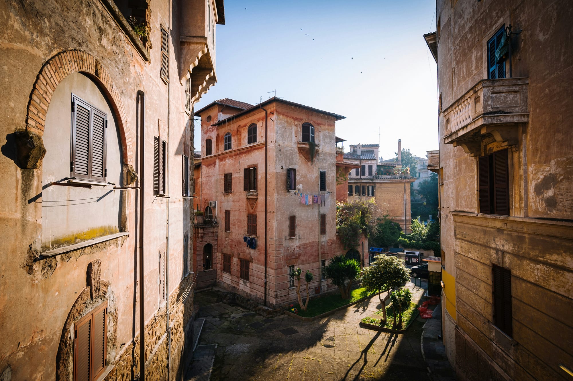 A narrow, colorful street runs through one of Rome's neighborhoods.