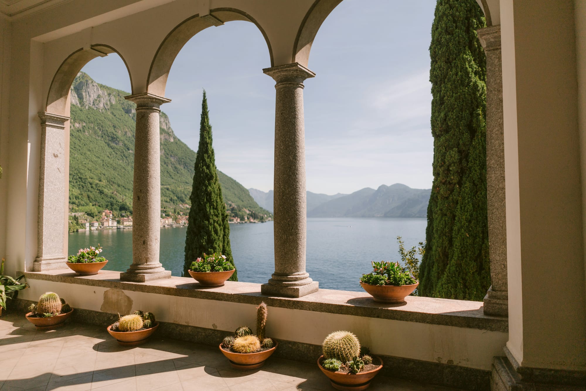 The famous arched loggia of Villa del Monastero (Varenna) overlooking the blue water of Lake Como.