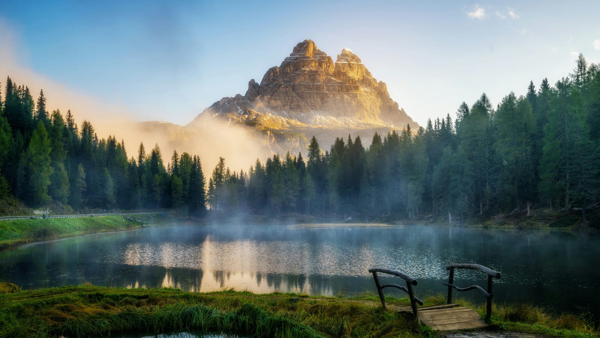 The first light of dawn appears over the Dolomites in Italy, and frost covers the ground.